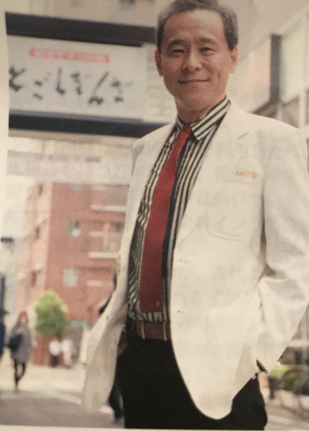 戸越銀座商店街のゲート前に立つ院長 秋津壽男